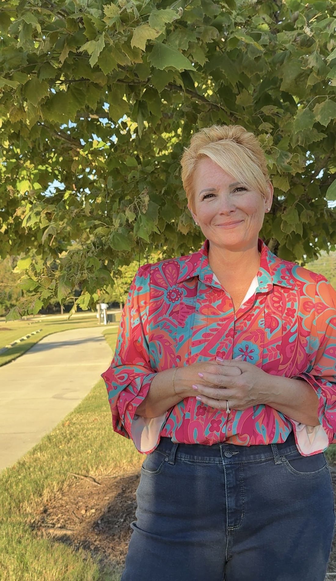 Lisa Davey smiling outdoors under a tree in Sumter